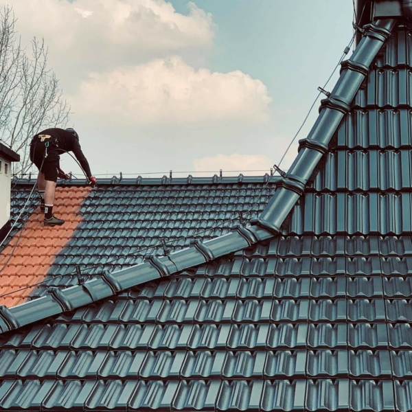 malowanie-dachówki-ceramicznej-Kraków-Zielonki-RAL-7021 Pracownik Biotop przy malowaniu dachówki ceramicznej